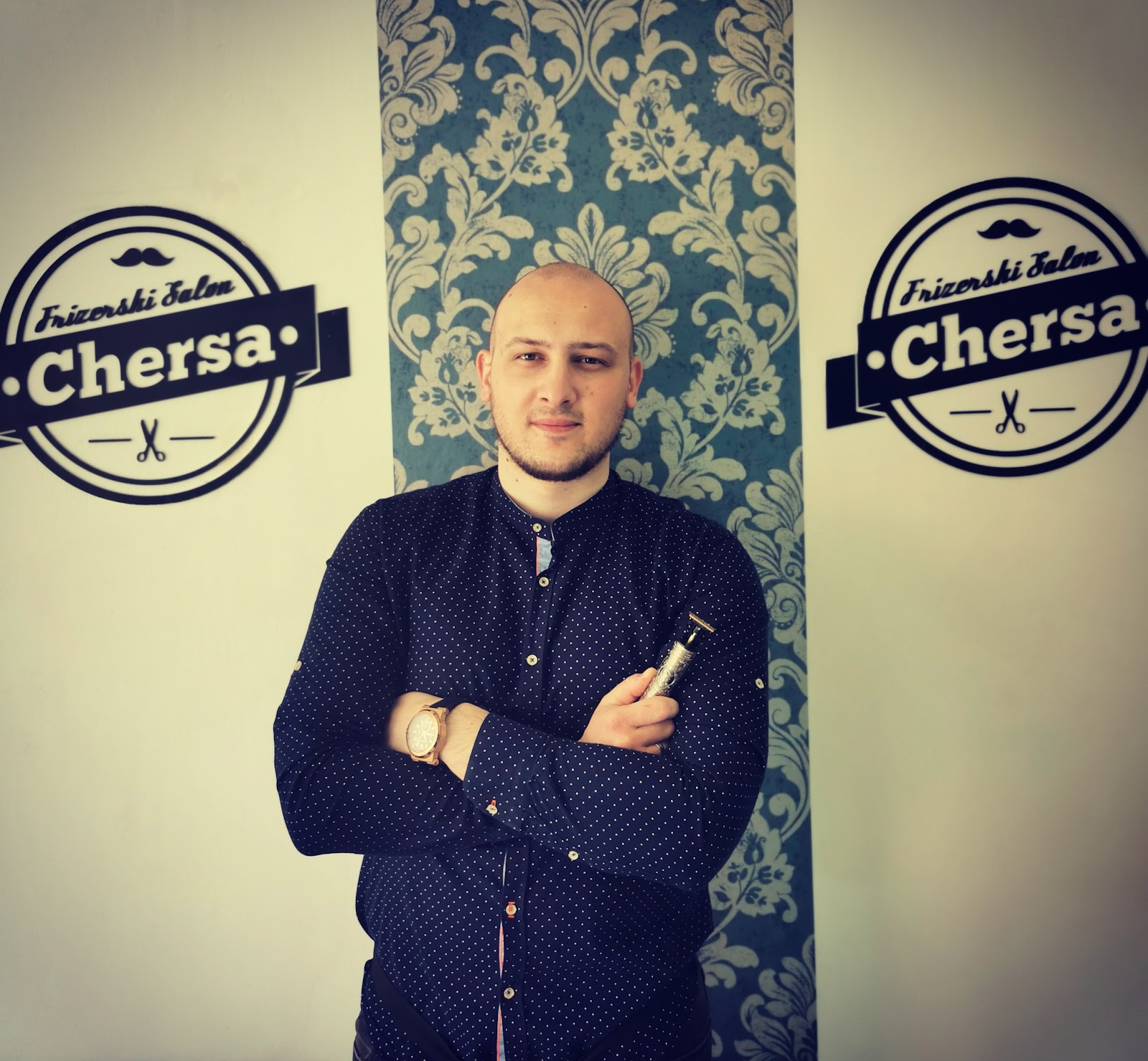 Mersad Fazlić, frizer i vlasnik salona Chersa, ispred logotipa salona
