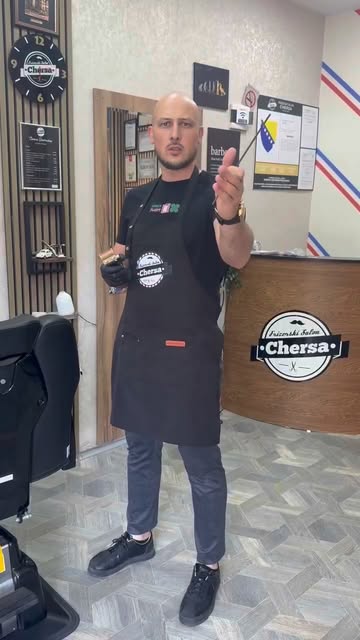 Mersad ispred recepcije salona sa škarama u ruci